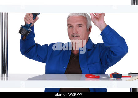 Builder putting up shelves Stock Photo