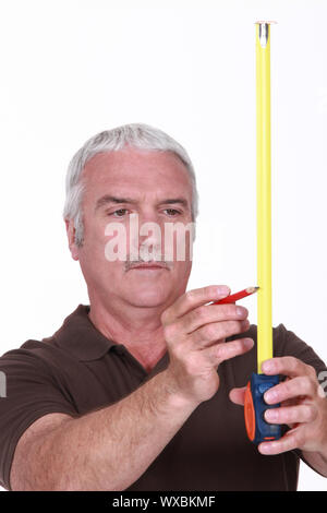 Man using tape measure and pencil Stock Photo