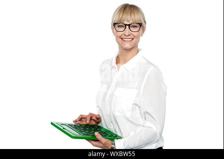 Secretary using large green calculator. Finger on subtract key. Stock Photo