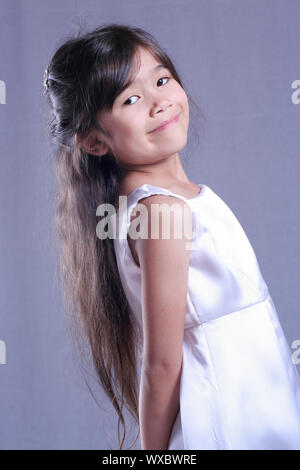 Beautiful little girl in white satin dress Stock Photo