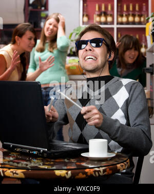 Obnoxious young man singing loudly in a coffee house Stock Photo