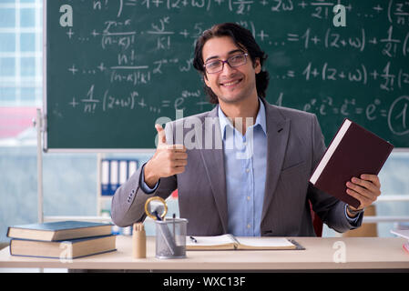 Young handsome math teacher in classroom Stock Photo