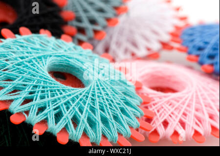 Many bobbins with different colored threads for sewing Stock Photo