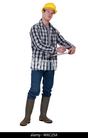 Builder writing on clip-board Stock Photo