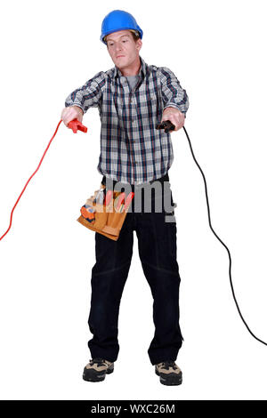 Electrician holding jumper cables Stock Photo