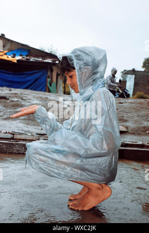 boy wearing water rain wet puddle walks boots through young alamy rainbows village indian