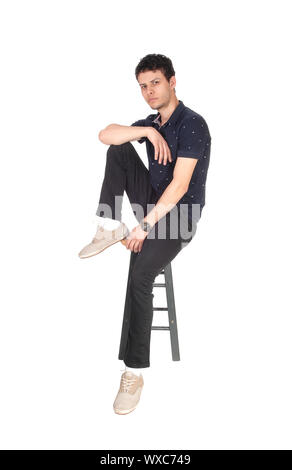 Handsome tall young man sitting on chair Stock Photo