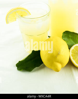 fresh organic lemonade in a jar with lemons and leaves and a glass of lemonade Stock Photo