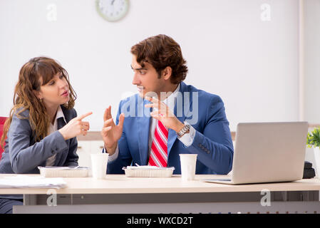Two colleagues having lunch break at workplace Stock Photo