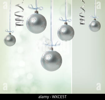 Silver Christmas Ornaments over glowing background Stock Photo