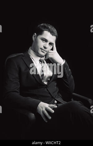 Young man wearing suit with tie sitting waiting Stock Photo