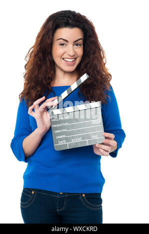 Charming woman posing with clapperboard in hands. All on white background. Stock Photo