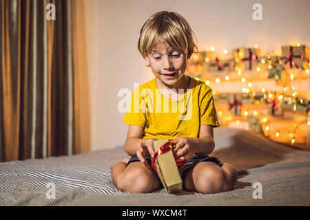 The boy opens a gift from the advent calendar Stock Photo