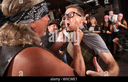 Nerd grabbed by collar in bar fight with tough gang member Stock Photo