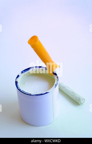 Home improvement painting roller resting on paint tin container. Stock Photo