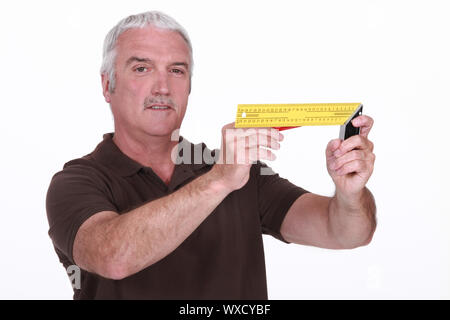 Grey-haired carpenter holding measuring device Stock Photo
