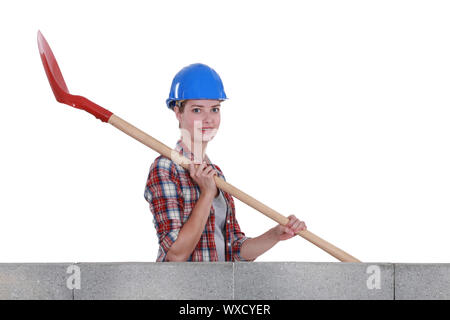 Female mason holding shovel Stock Photo