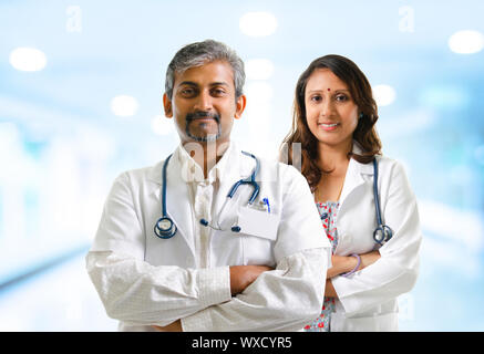 Indian doctors or medical tem crossed arms standing, hospital background Stock Photo