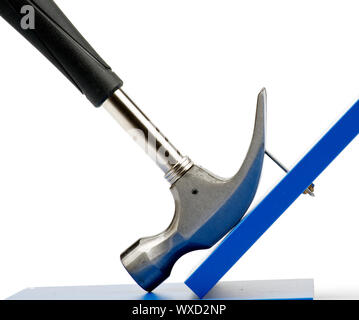 Hammer Pulling Nail Out of Blue Plank closeup on white background Stock Photo