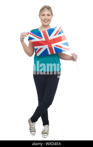 Pretty teenager female model holding British flag. Striking stylish pose with legs crossed. Stock Photo