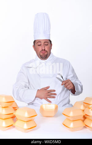 chef sick after eating too many burgers Stock Photo