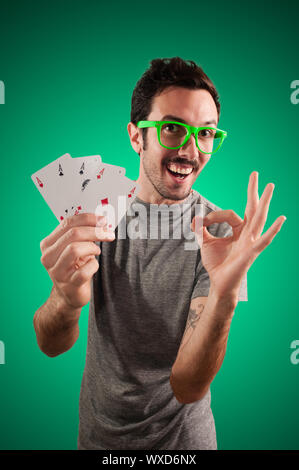 winner guy holding poker cards on green background Stock Photo