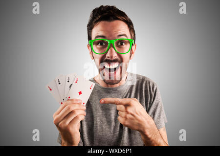 winner guy holding poker cards on grey background Stock Photo