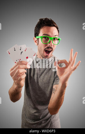 winner guy holding poker cards on grey background Stock Photo