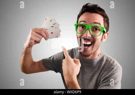 winner guy holding poker cards on grey background Stock Photo