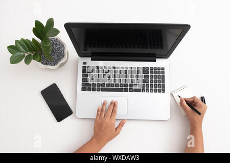 Office work flat lay Girl writing to-do list in her notebook Stock Photo