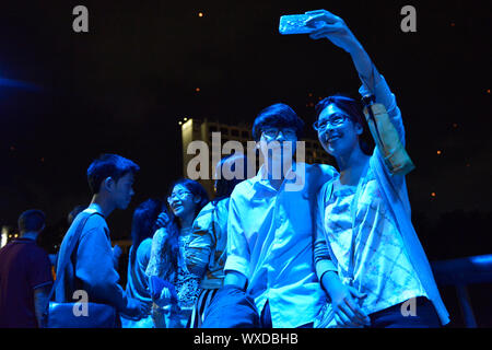 Young people gathering outside at night and making selfies during the celebration of the annual festival Loi Krathong in Chiang Mai, Chiang Mai Province, northern Thailand, Thailand, Southeast Asia, Asia. Stock Photo