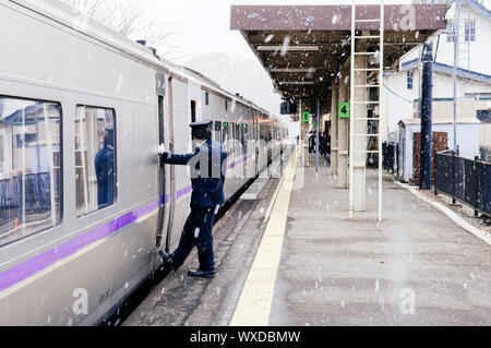 DEC 1, 2018 Hakodate, JAPAN - JR Suoer Hokuto train stop at Onuma Koen station  platform during snow fall in winter with train conductor staff stand a Stock Photo