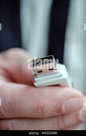 Closeup of a male hand holding usb key towards you. Stock Photo