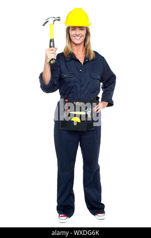 Full length shot of a business architect displaying hammer to the camera. Stock Photo