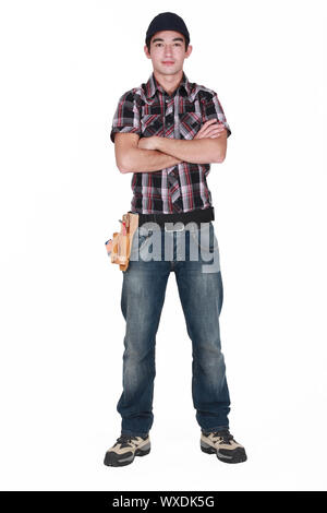 Young builder stood with arms folded Stock Photo