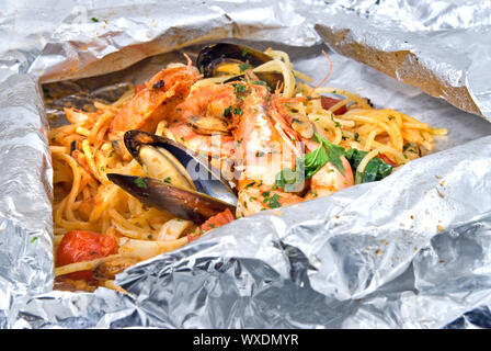 pasta with oysters and tomato in foil Stock Photo