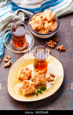 Traditional Turkish arabic dessert and a glass of tea with mint Stock Photo