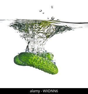 green cucumbers dropped into water isolated on white Stock Photo
