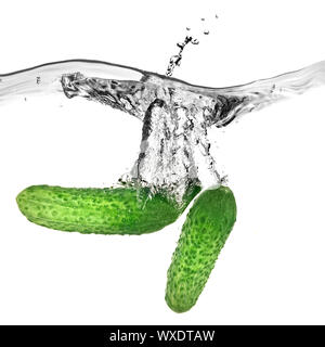 green cucumbers dropped into water isolated on white Stock Photo