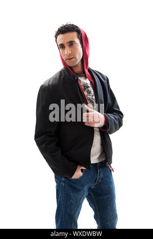 Cool handsome male wearing a red hoodie, black coat and jeans, with hands in pocket, isolated Stock Photo