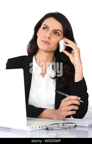 Assistant having phone call, studio shot Stock Photo