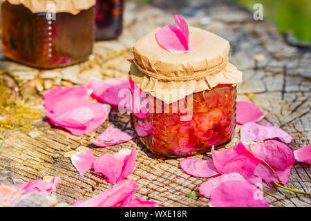 Jam from rose with rose petals on stump Stock Photo