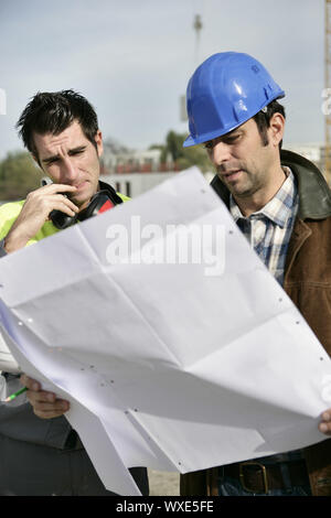 Foreman and colleague checking over plans Stock Photo