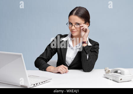 Casual business woman in office working with white table, laptop and phone Stock Photo