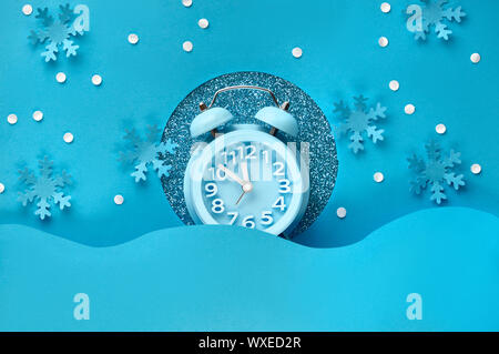 Happy New Year 2020! Aarm clock in paper hole, flat lay on blue color paper background Stock Photo