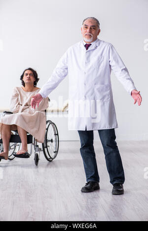 Old male doctor psychiatrist and patient in wheel-chair Stock Photo