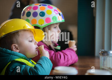 Sibling eating ice creams in a cafe Stock Photo