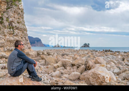 Man resting on the rocky coast Stock Photo