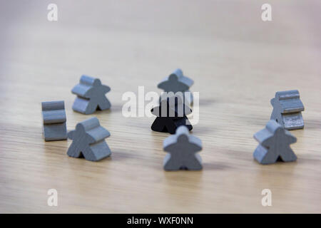 Gray gaming pieces and a black meeple, diversity concept Stock Photo