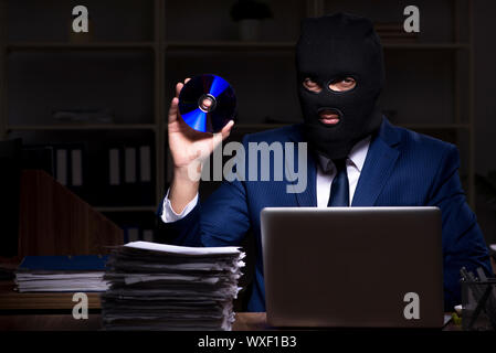 Male employee stealing information in the office night time Stock Photo